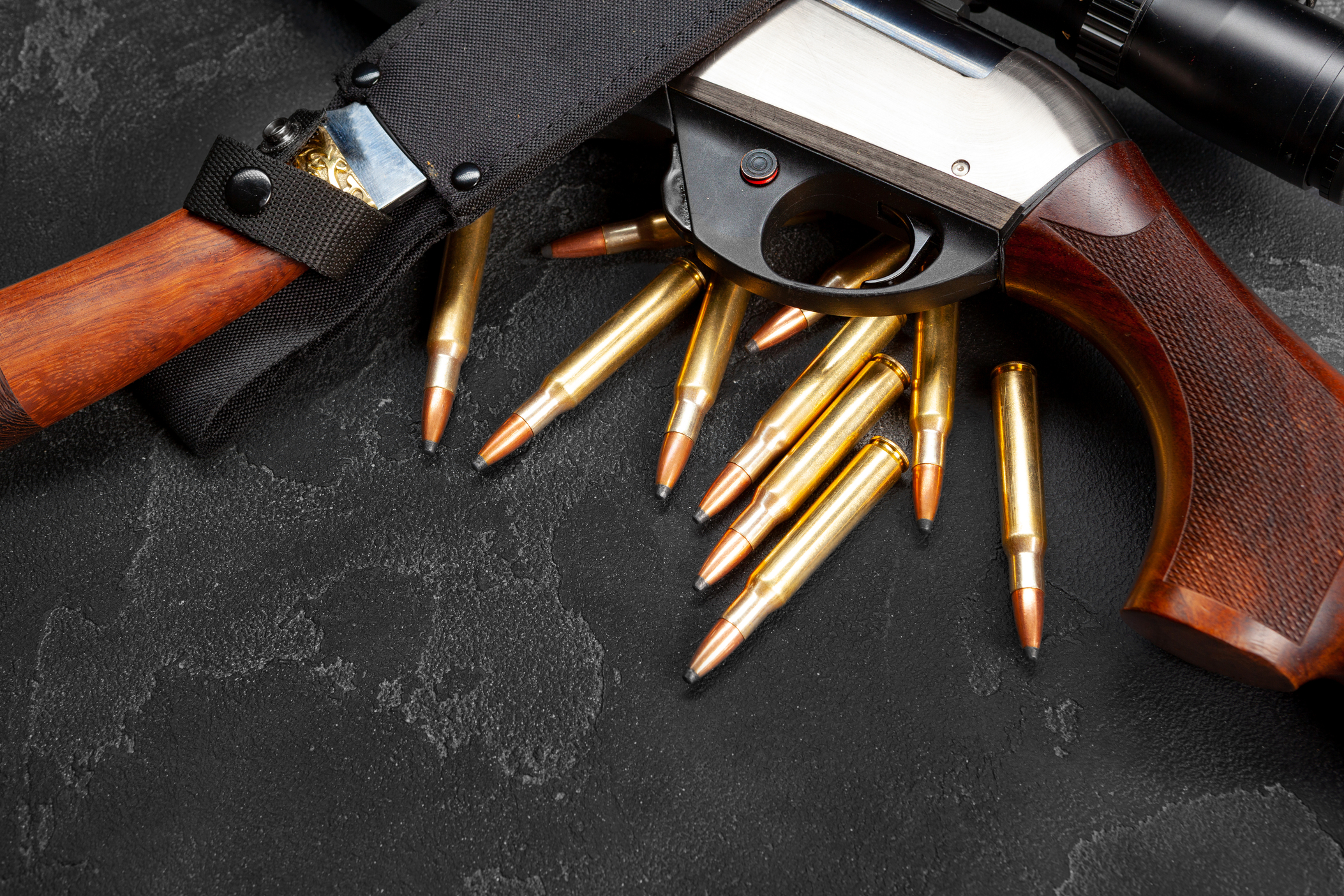 Close up of hunting shotgun and cartridges on dark grey background